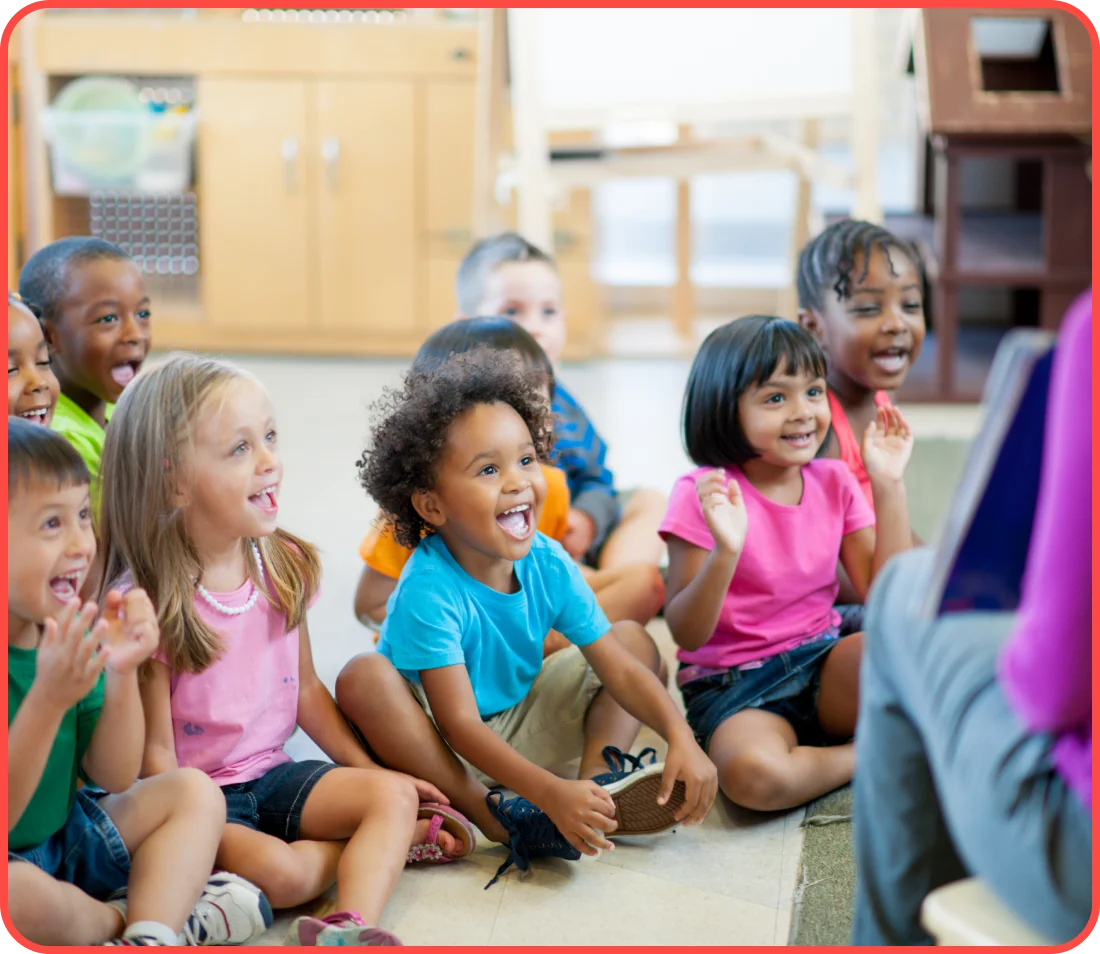 A group of children sitting in front of a person.