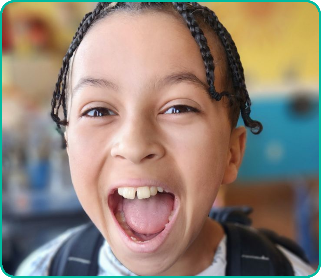 A young girl with braids is making an open mouth.